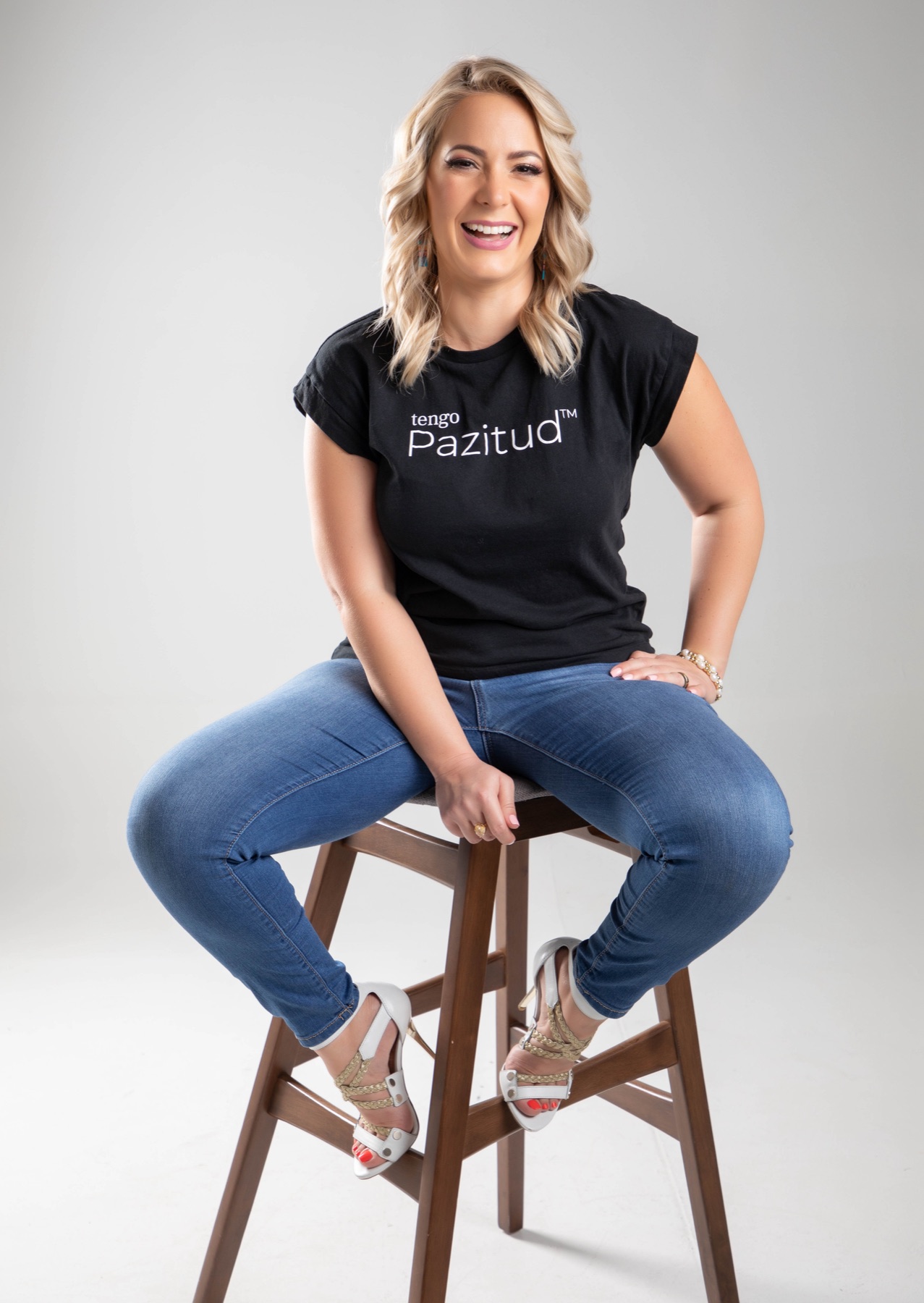 Yane Díaz riéndose en un banco con su camiseta de tengo Pazitud