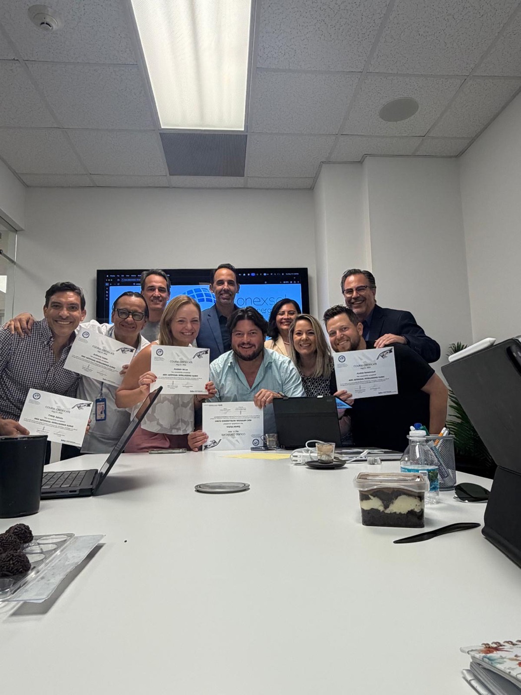 El equipo de la empresa de energía solar Conexsol con sus certificados del curso de IA en su sala de reuniones