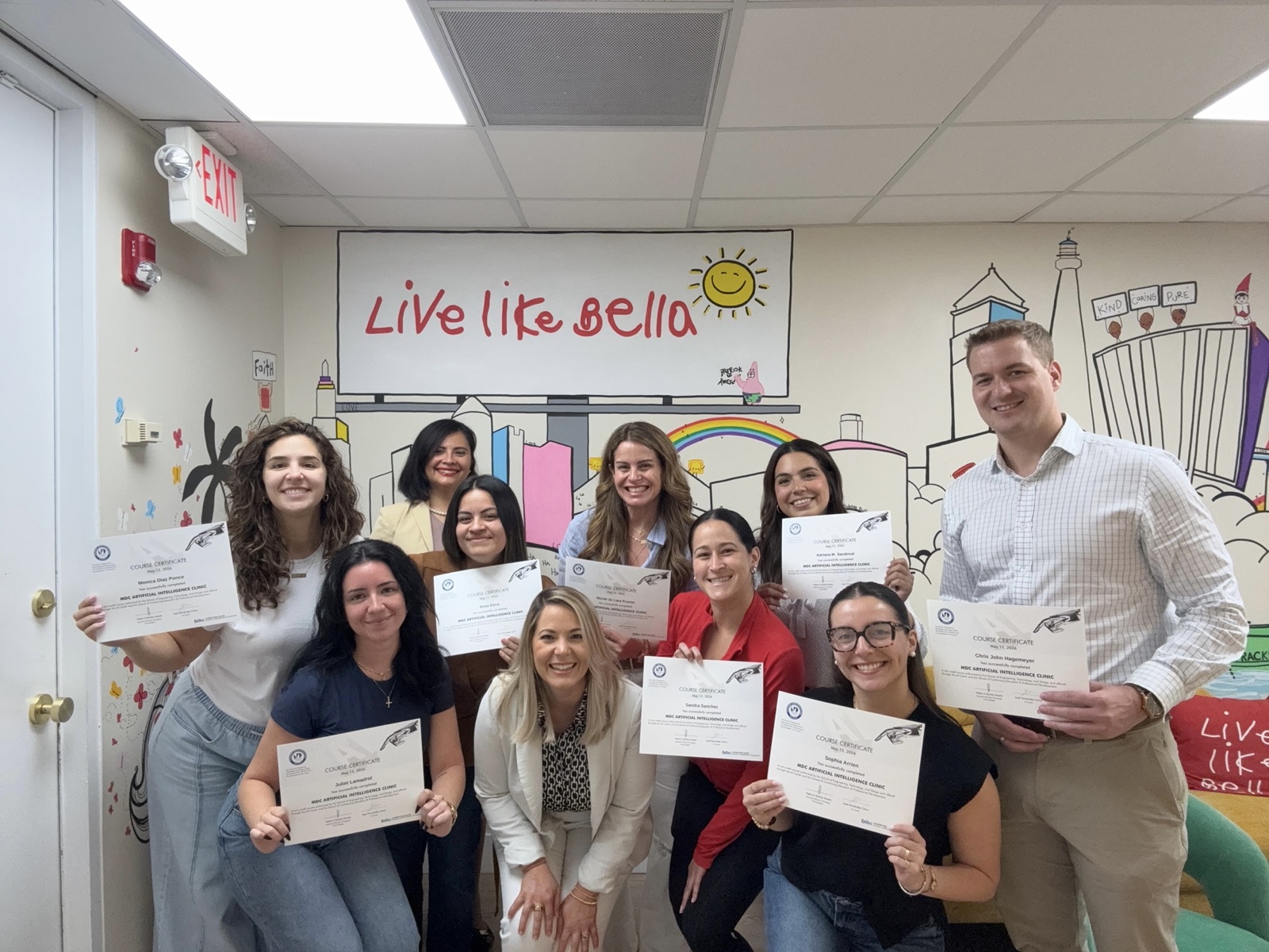 El equipo de la organización sin fines de lucro Live Like Bella con sus certificados de la Clínica de IA en su oficina